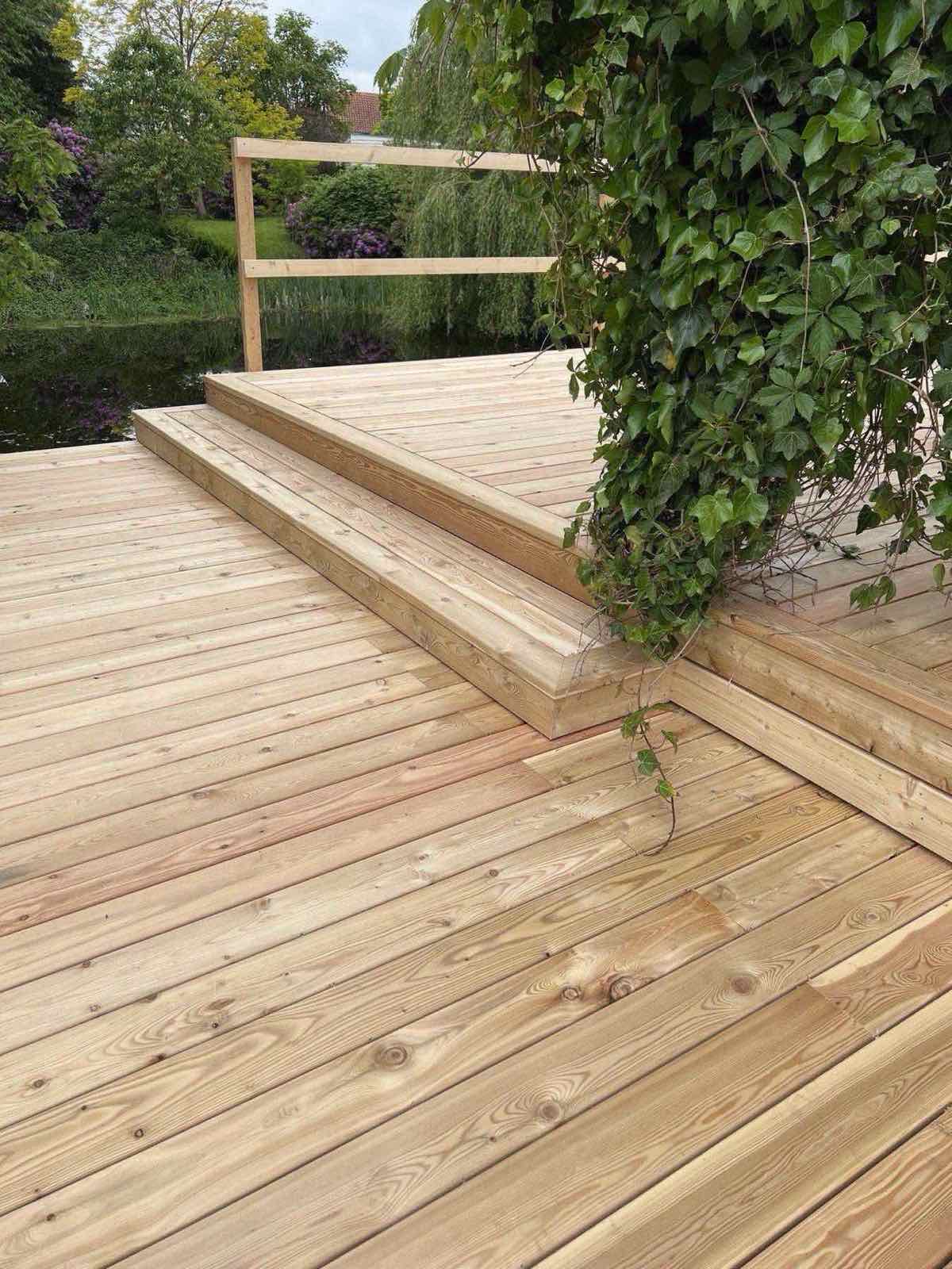Træterrasse med glasværn og hævet konstruktion